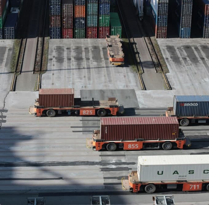 Bãi container tại cảng, xe đầu kéo đang kéo container ra khỏi bãi